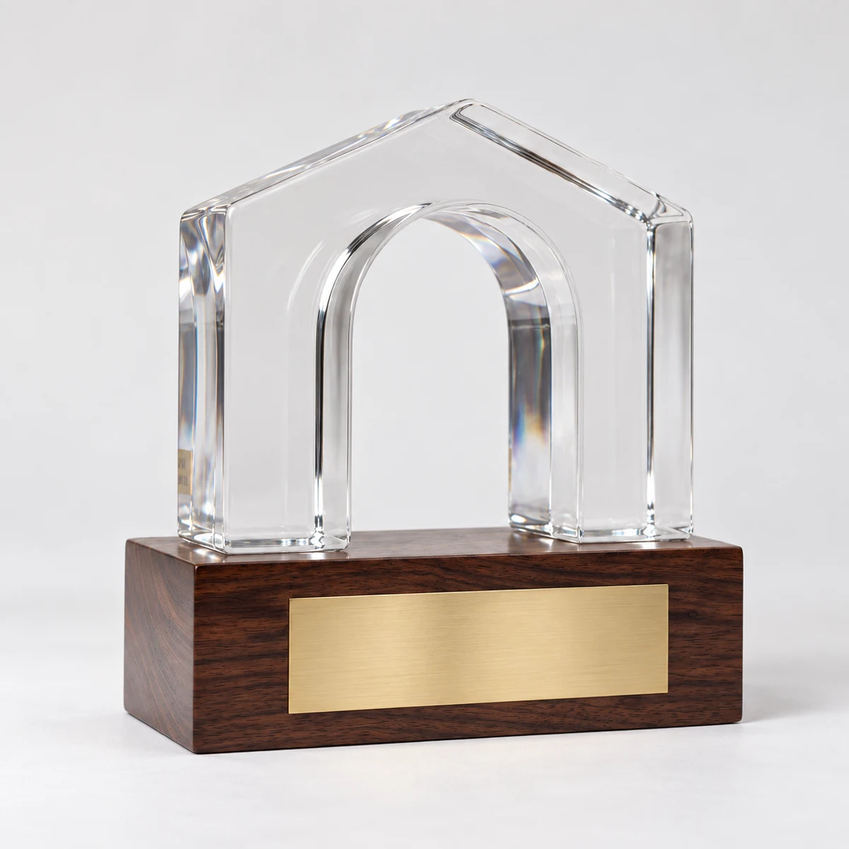 A clear house-shaped arch on a wood base offers a simple architectural expression.